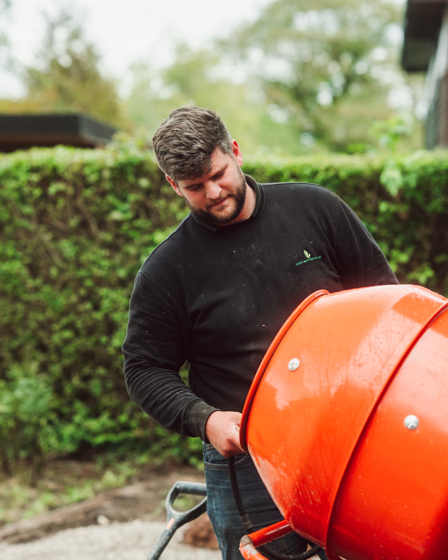 Landscaper pouring from an orange cement mixer