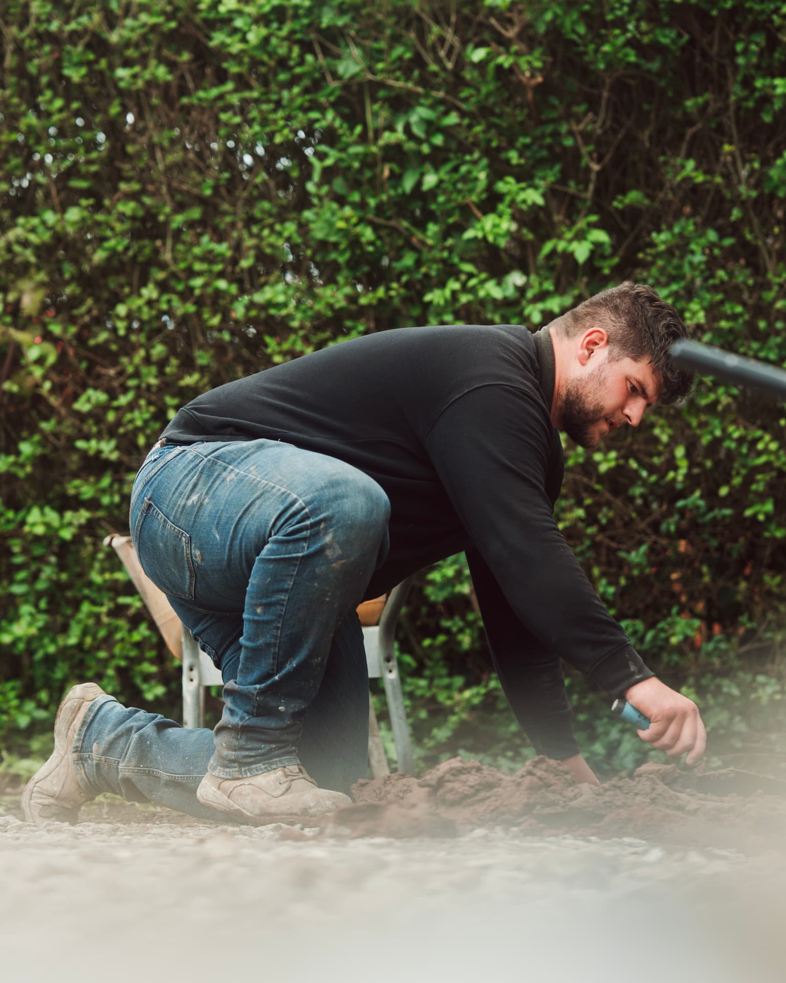 Landscaper running a breaker on dusty ground